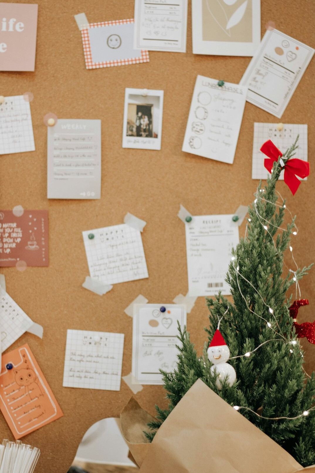 Corkboard with pinned photographs, red string and handwritten notes