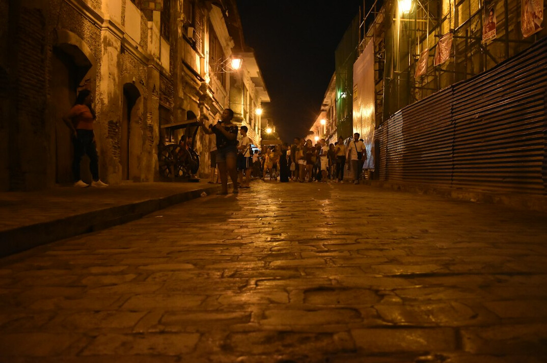Rainy cobblestone street in an old South American colonial town at dusk