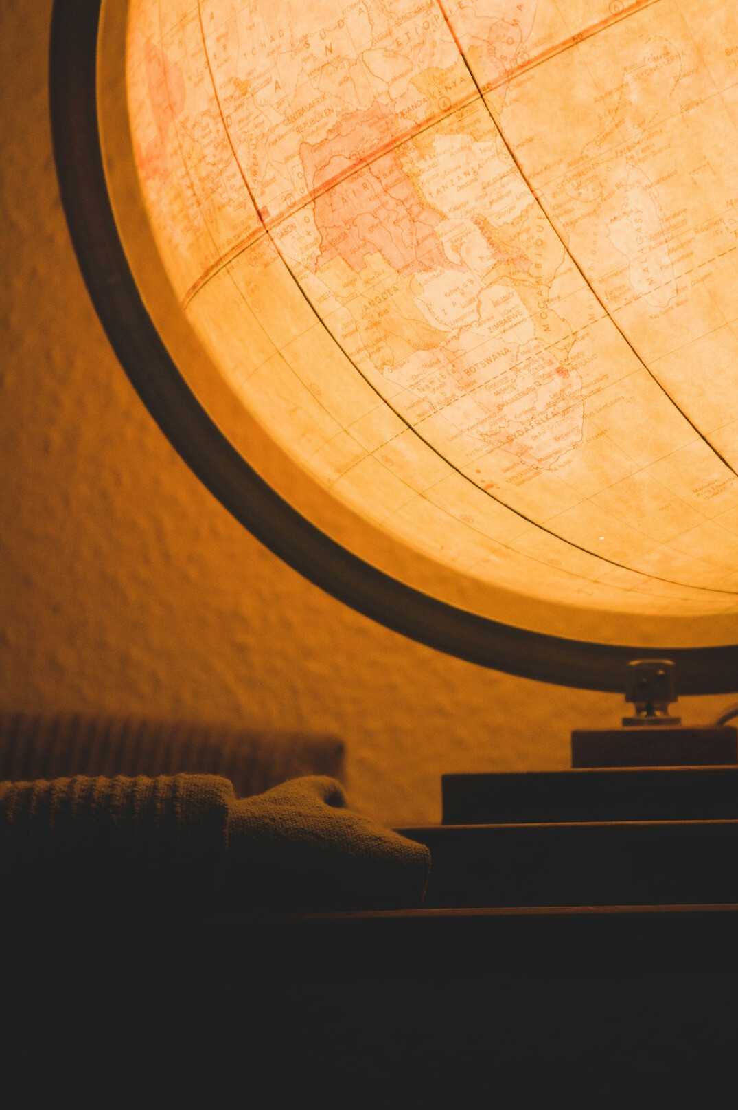 Detective's desk with an old notebook, magnifying glass and a vintage map under warm lamp light