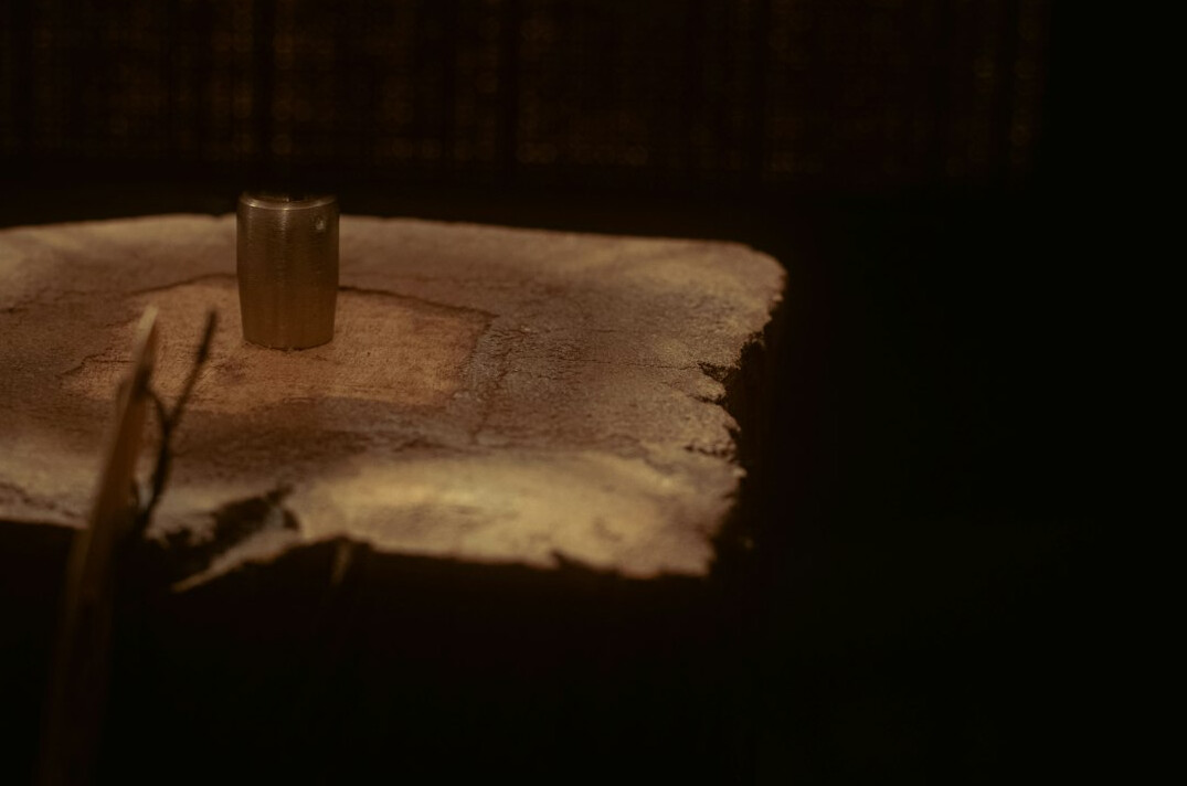 Open manuscript pages with a fountain pen resting on a desk under warm light