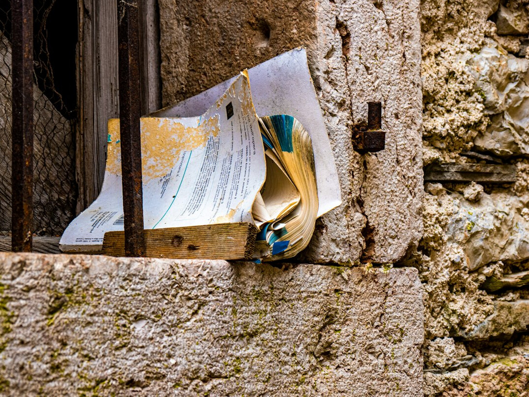 Close-up of old case files, yellowed documents and a magnifying glass on a wooden table